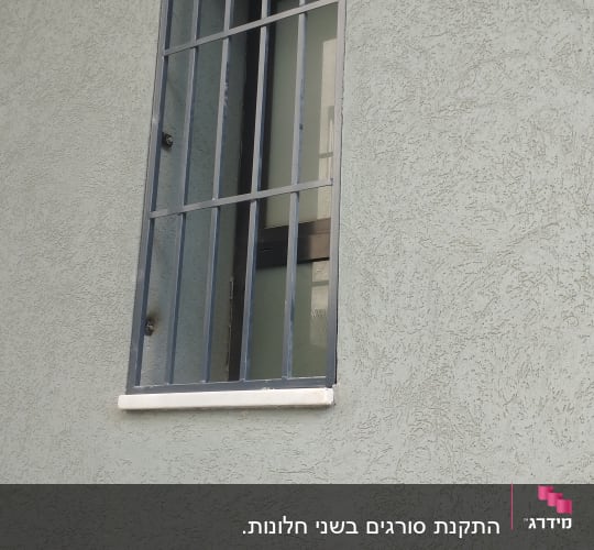 סורג ישר מברזל בצבע אפור כהה המותקן על חלון בית